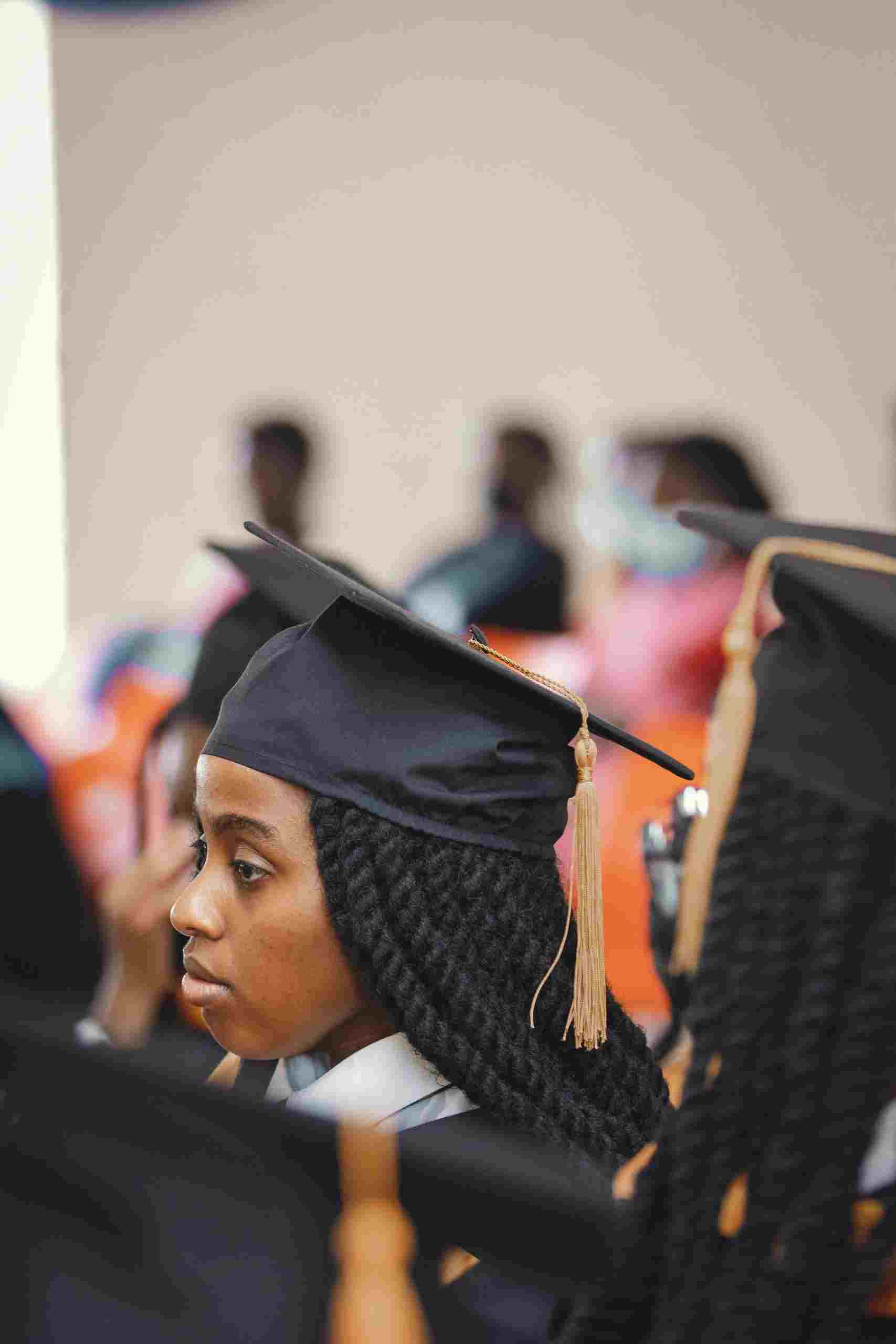 Graduate student wearing a cap and gown at a commencement ceremony while exploring Refinance Federal Student Loans, evaluating Student Loans for Graduate School, researching a Graduate Plus Loan, considering Student Loan Refinance for Medical School Debt, and using a Student Loan Calculator to estimate repayment costs.