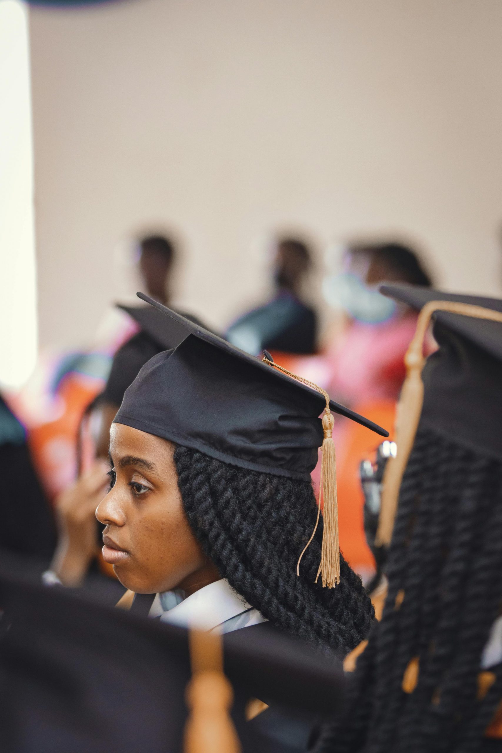 Graduate student wearing a cap and gown during a commencement ceremony while exploring Refinance Federal Student Loans, evaluating Student Loans for Graduate School, reviewing a Graduate Plus Loan, researching Student Loan Refinance for Medical School Debt, and using a Student Loan Calculator to estimate future repayment costs.