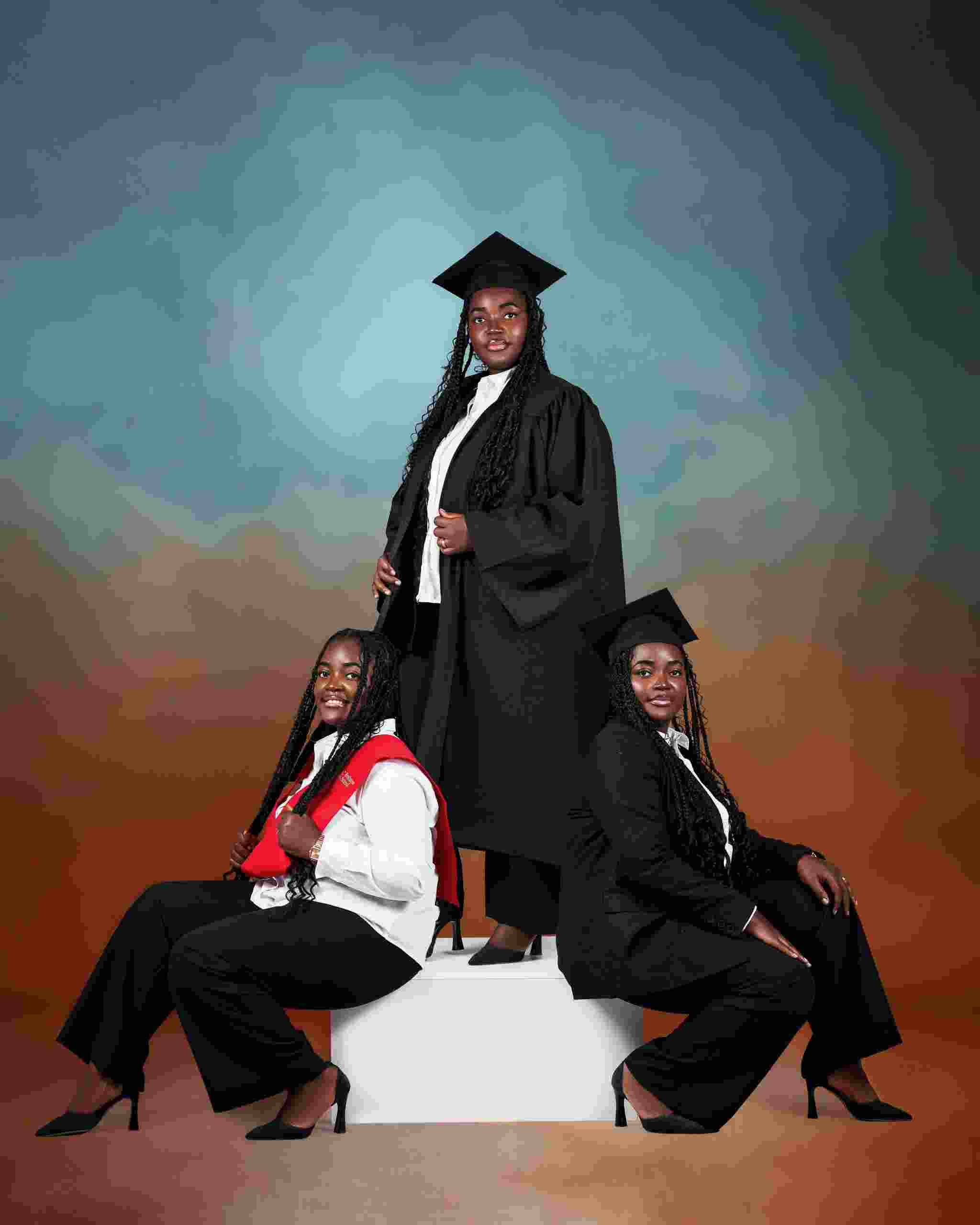 Three graduates in formal academic attire pose proudly after completing their studies while researching Review our Terms and Conditions for Student Loan Refinancing, comparing Student Loan Refinance Rates, and learning How to Refinance Student Loans to reduce education debt and improve repayment options.