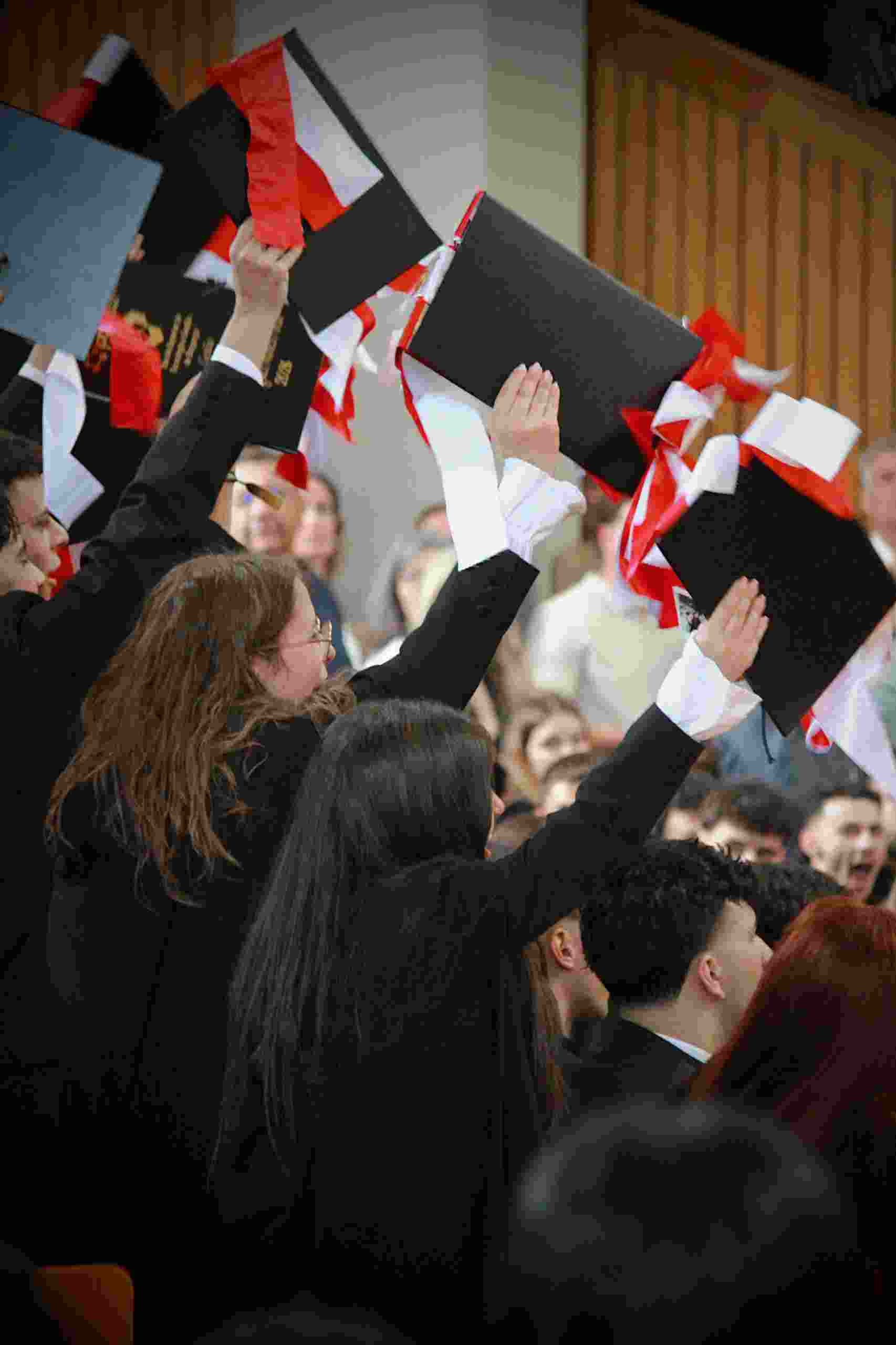 Graduates celebrate their achievements by raising diplomas during a commencement ceremony while exploring whether Should I Refinance my Student Loans, reviewing a Privacy Policy, comparing options with a Student Loan Refinance Calculator, understanding Student Loan Refinance Terms, and learning When to Refinance Student Loans for better financial outcomes.