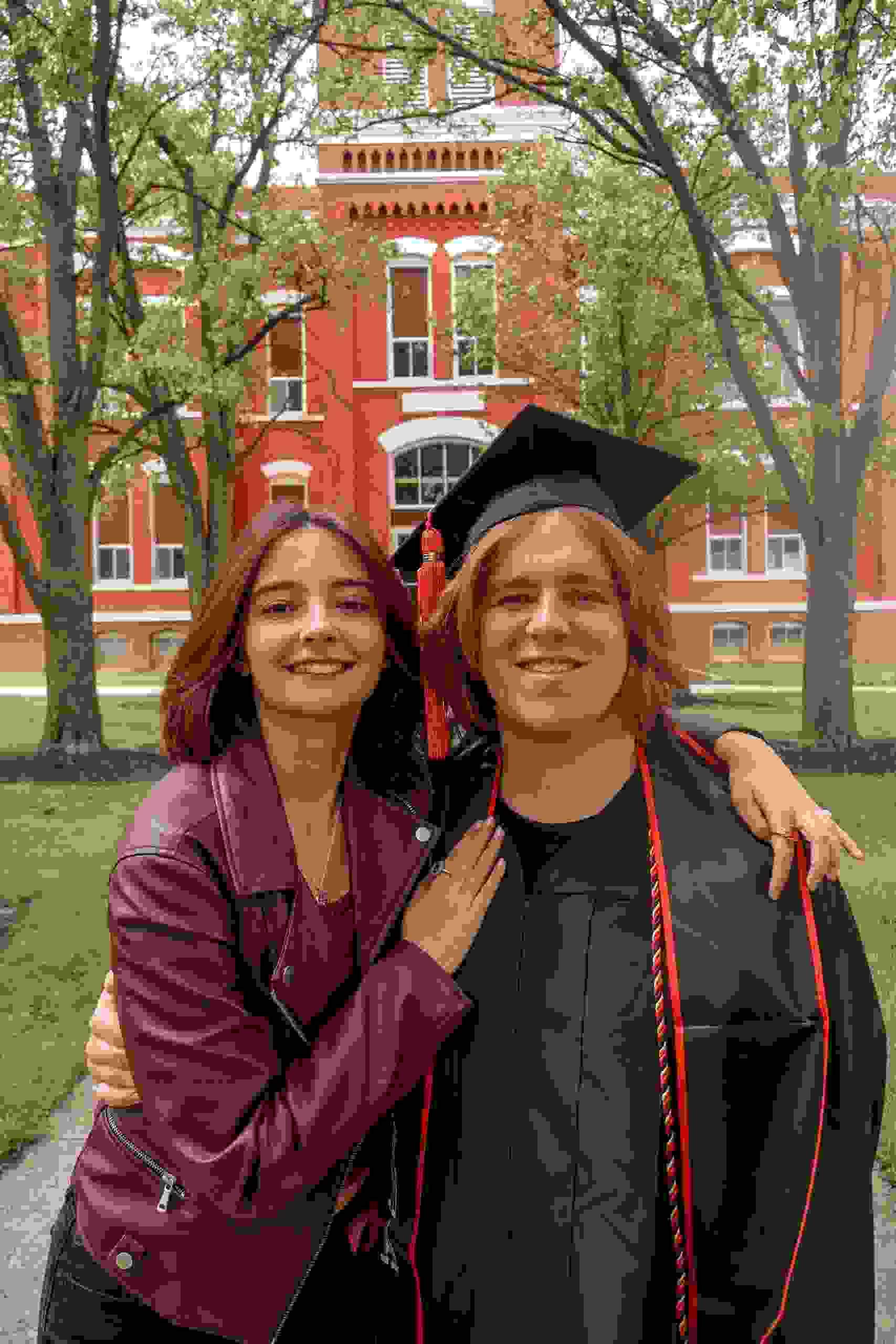 Proud graduate standing with a family member on a college campus while exploring Online Student Loan Refinance options, comparing Private Student borrowing solutions, evaluating Private School Loans, searching for the Lowest Student Loan Refinance Rates, and asking When Do Student Loans Resume after graduation.