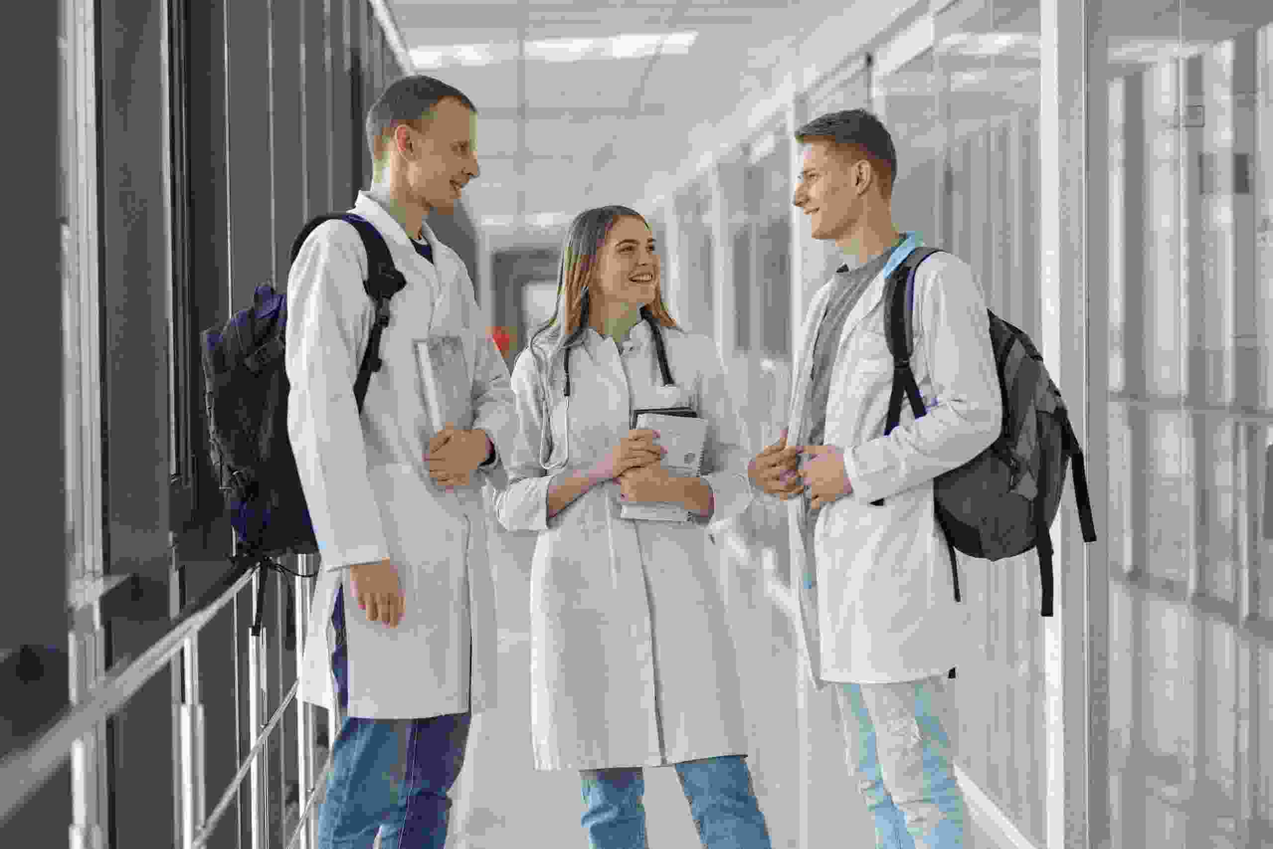 Medical and healthcare students standing together in a university hallway discussing education financing, comparing Should I Refinance Student Loans, understanding Student Aid, reviewing an Advertising Disclosure, learning about the Student Loan Interest Deduction, and searching for Superb Student Loan Rates.