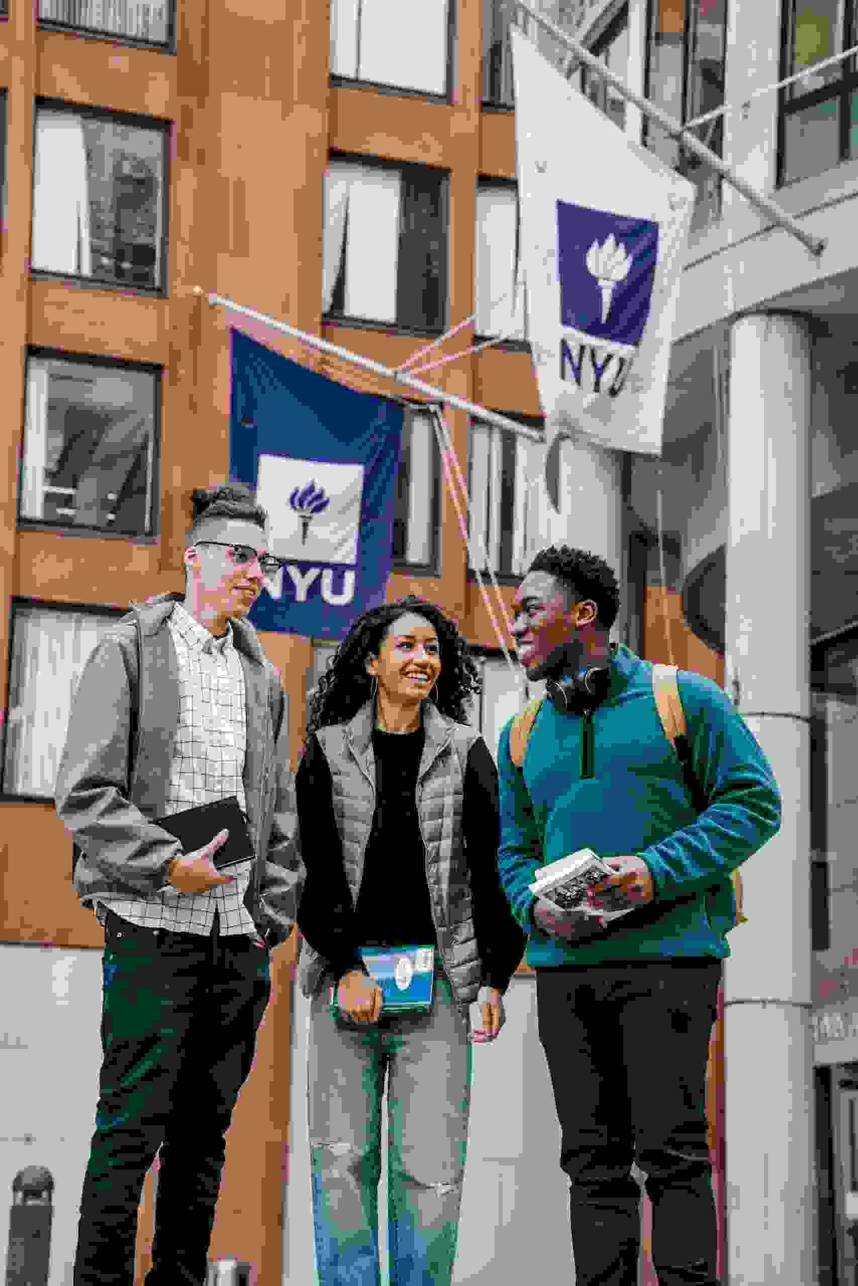 Three college students standing outside a university building while researching Student Loan Refinance Companies, learning how to Compare Student Loan Refinance Lenders, exploring options to Refinance Student Loans, determining Can You Refinance Private Student Loans, and reviewing Student Loans Refinance opportunities to reduce borrowing costs.