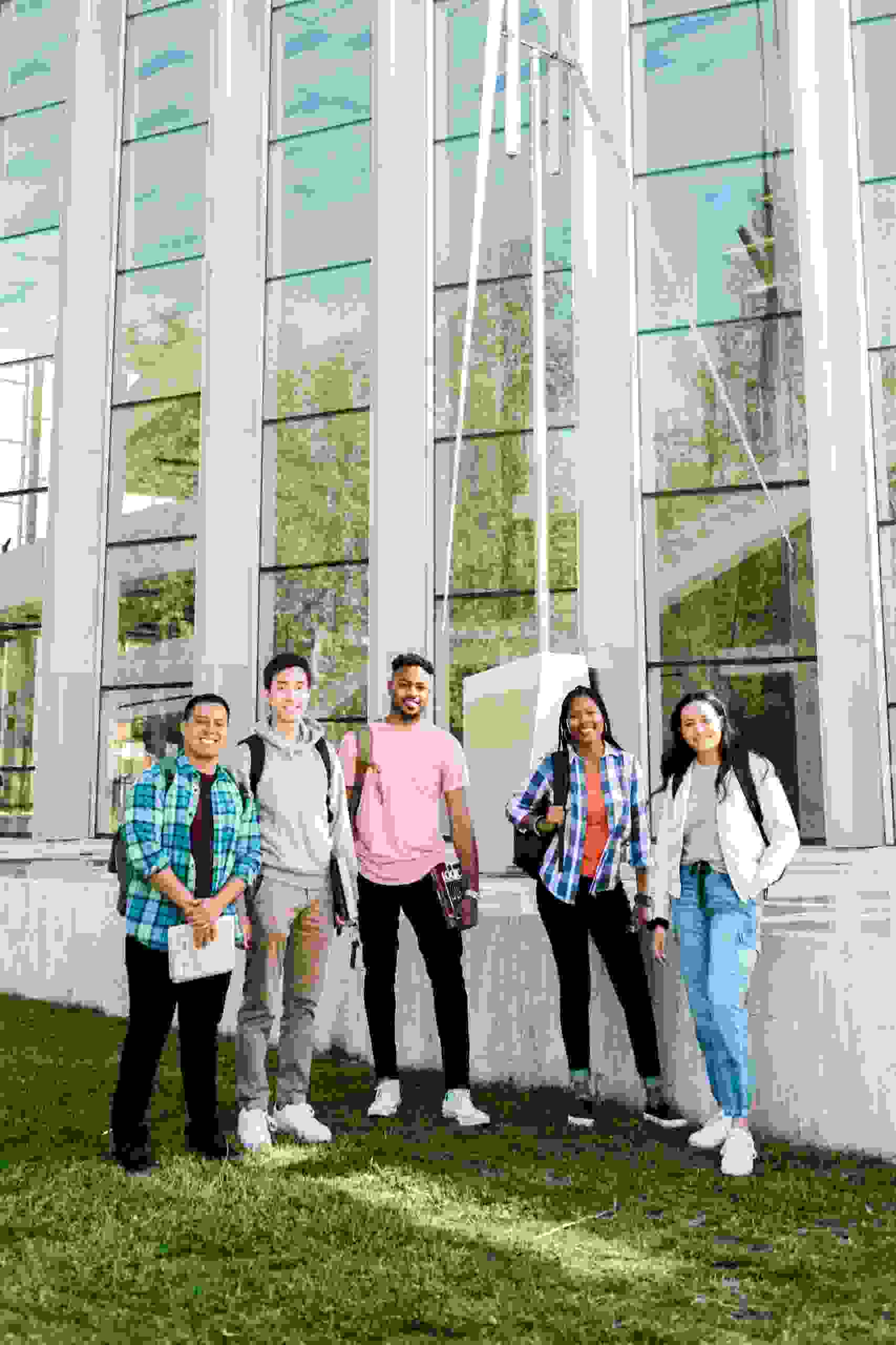 Group of diverse college students standing outside a campus academic building while researching how to Compare Student Loan Refinance Rates, exploring Can You Refinance Student Loans options, learning How to Refinance Student Loans, understanding How to Refinance a Student Loan, and reviewing current Refinance Student Loan Rates.