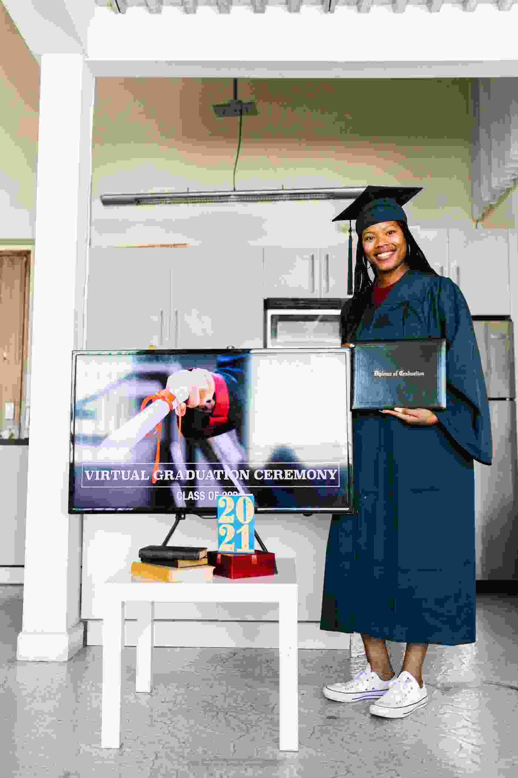 Graduate holding a diploma during a virtual graduation ceremony while researching Student Loan Refinance Reviews, exploring Student Loan Refinance for International Students, asking how to Refinance my Student Loans, reviewing information from Student Loan Gov resources, and comparing Student Loan Refinance options.